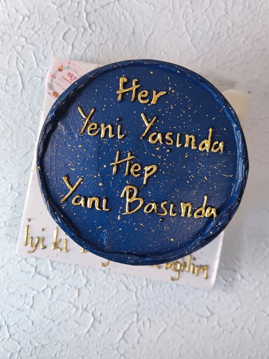 Lacivert kremalı, altın simli, üzerinde altın yazıyla 'Her yeni yaşında hep yanı başında' yazan bento pasta